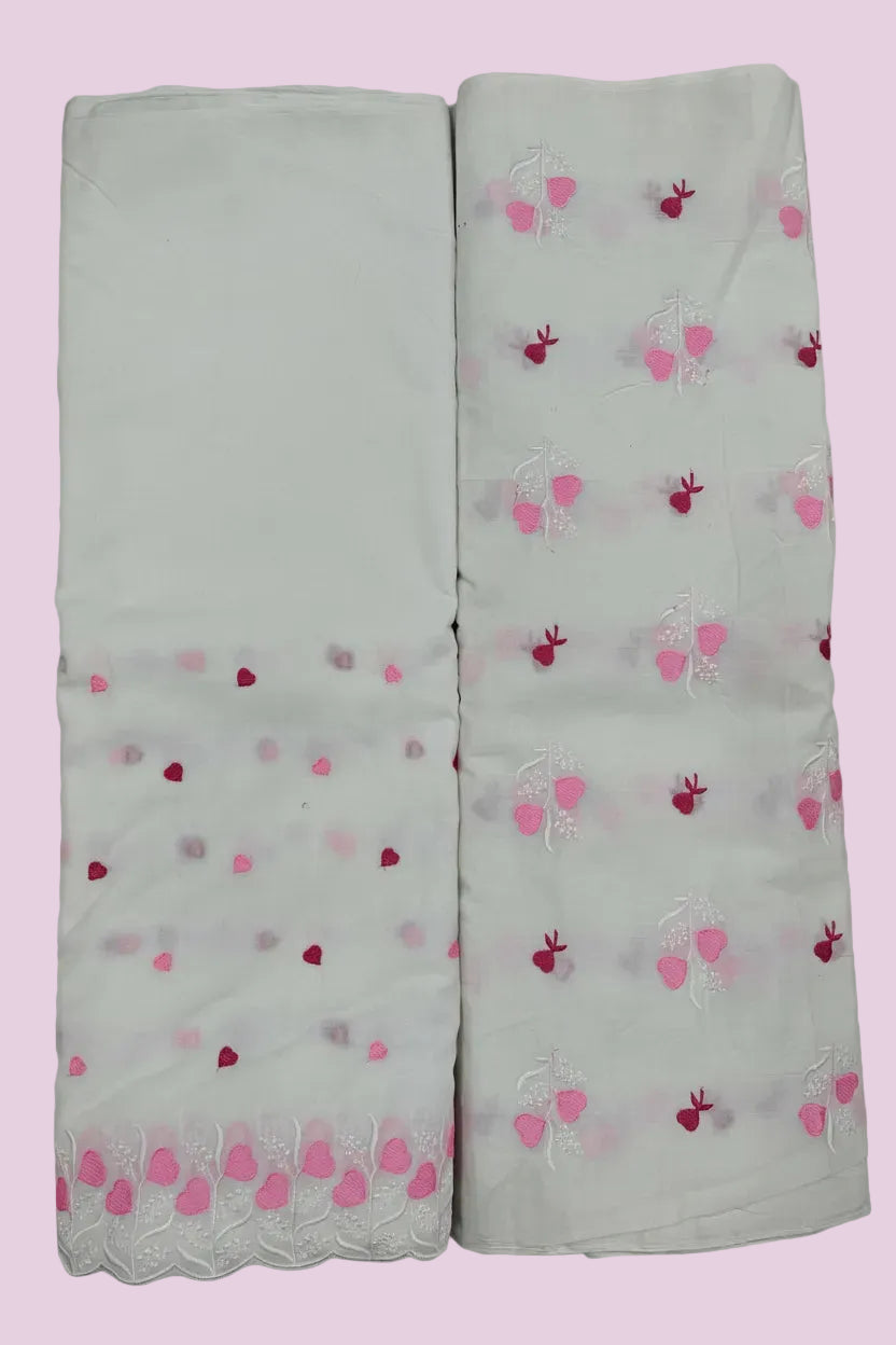 Two white scarves with pink and red heart patterns on a tiled floor.