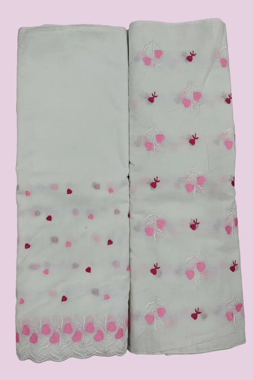 Two white scarves with pink and red heart patterns on a tiled floor.