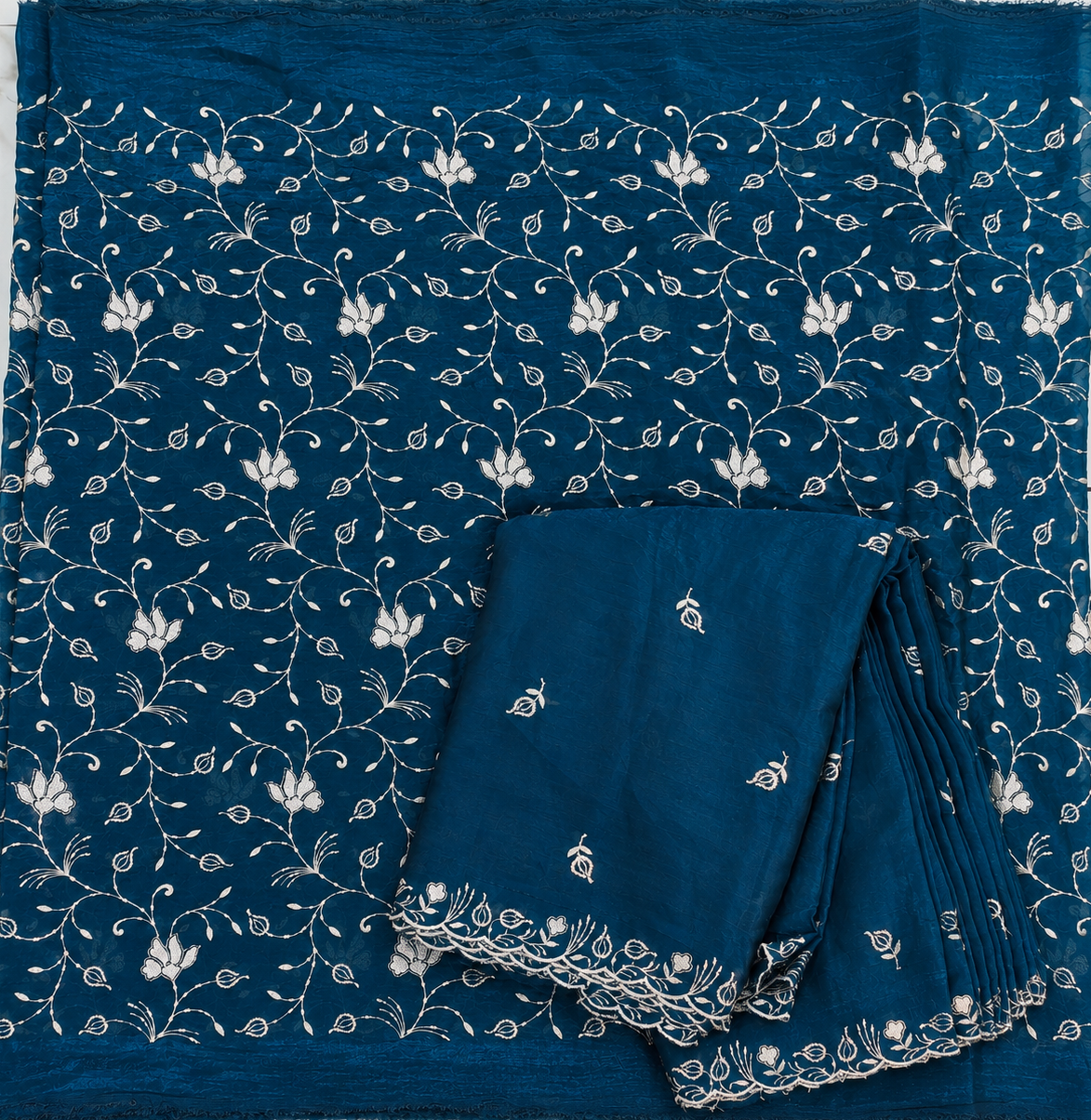 Blue fabric with white floral patterns on a tiled background